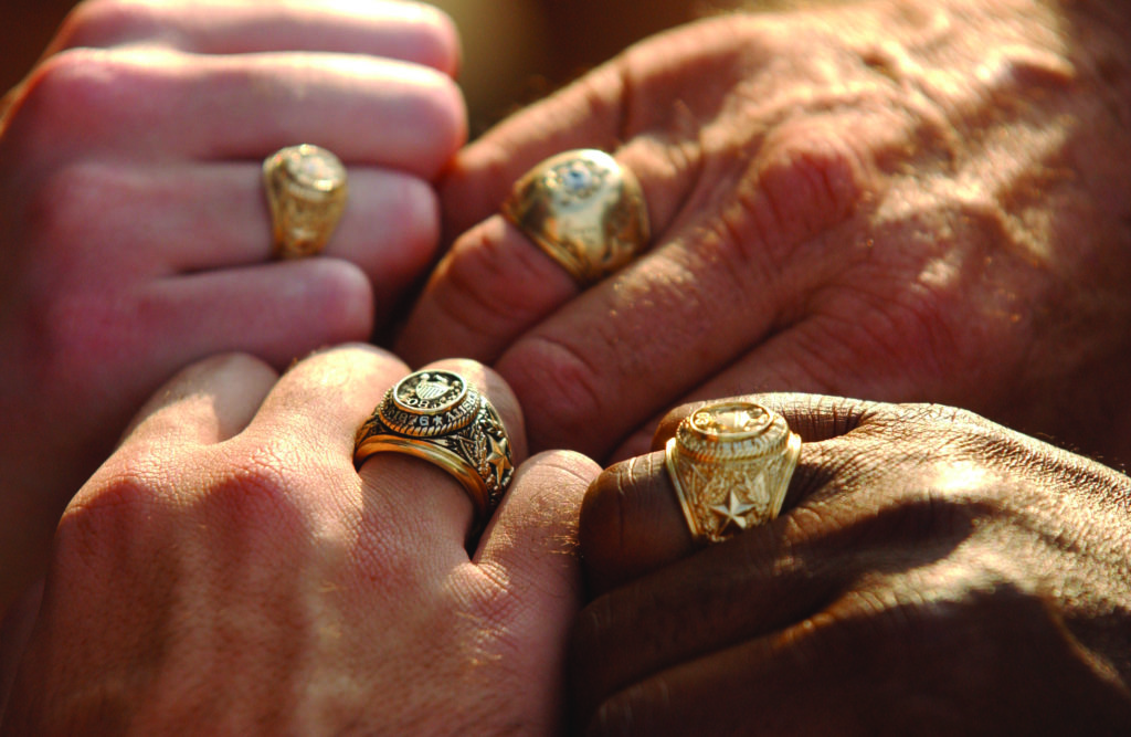 four hands with Aggie rings on fingers
