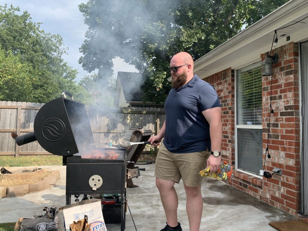 person grilling in a backyard