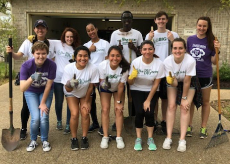 Group of students wearing "The Big Event" shirts posing with Gig 'Em thumbs