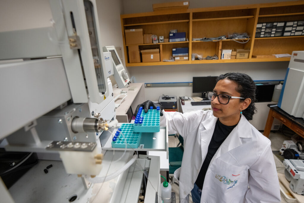 Student taking vials off a tray in lab