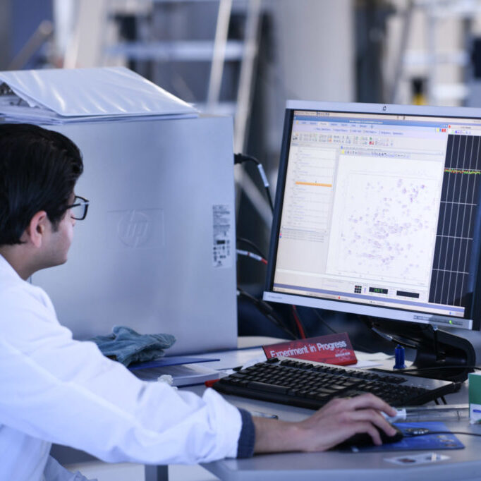 Student sitting in front of a monitor displaying data points