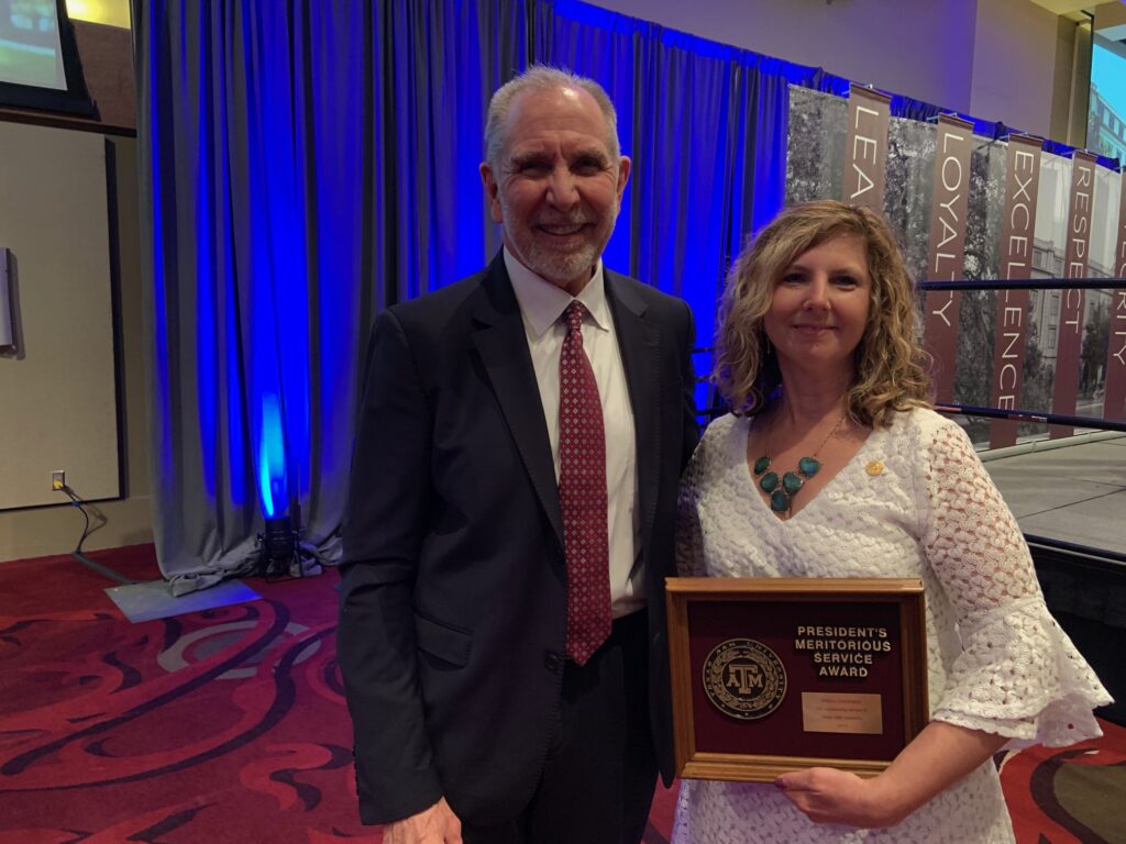 two people posing with President's Meritorious Service Award