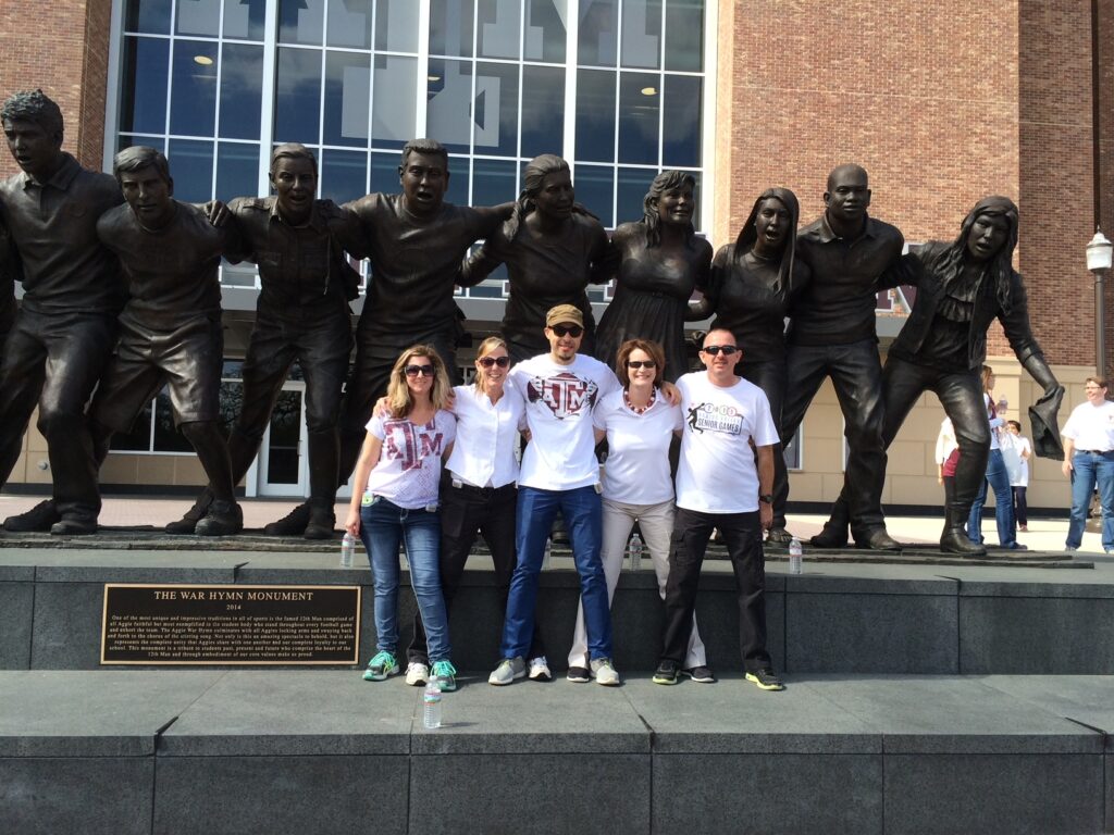 five people posing in front of War Hymn Monument