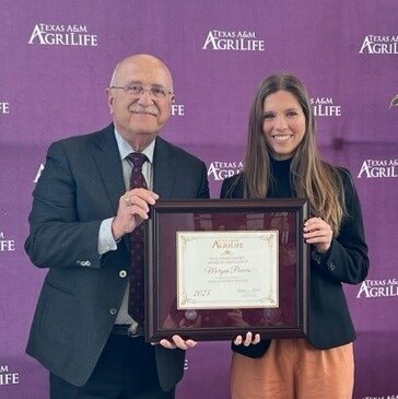 Morgan Powers holding an award with Dr. Savell